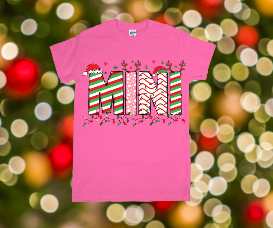 Pink t-shirt with Christmas-themed design on a blurred festive background