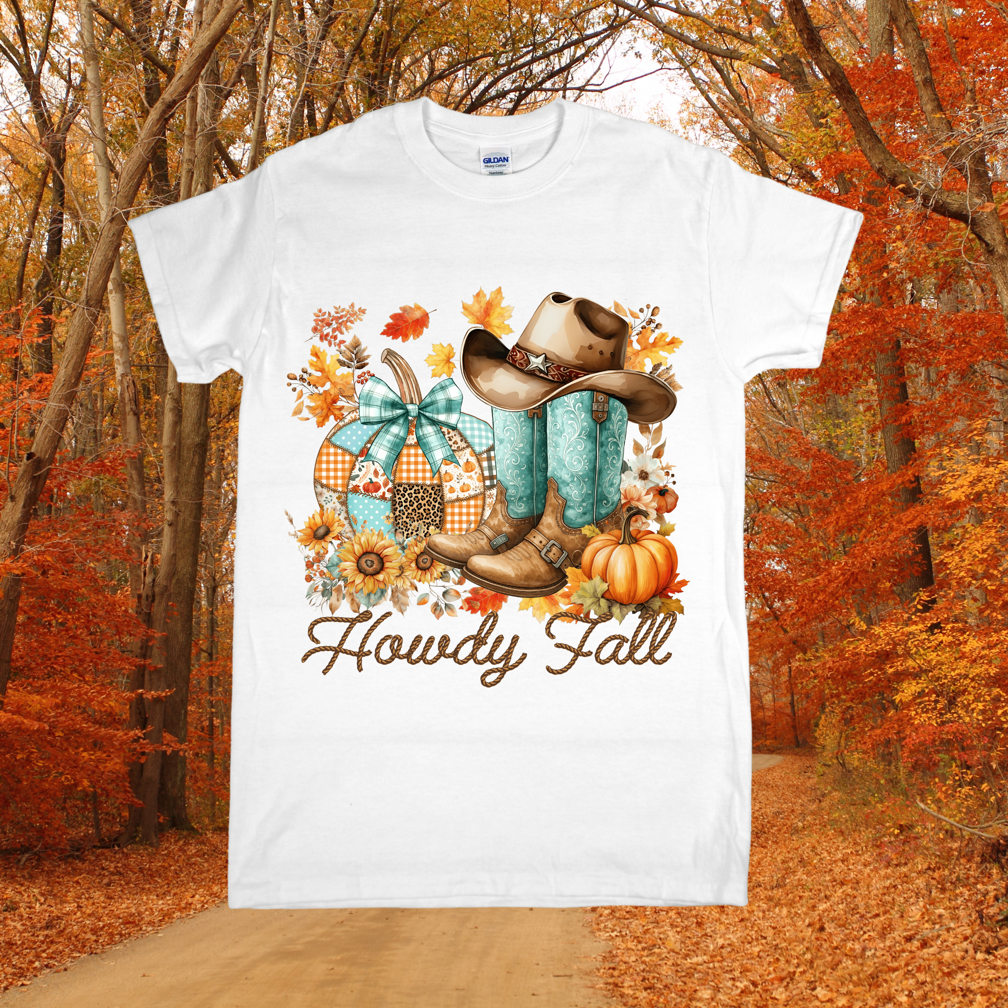 White t-shirt with autumn-themed design featuring boots, pumpkins, and 'Howdy Fall' text, set against a forest background.