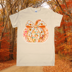 Beige t-shirt with a floral pumpkin design in an autumn forest setting