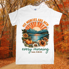 White t-shirt with autumn-themed design and text in a forest setting