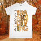 White t-shirt with 'Happy Thanksgiving' design in an autumn forest setting