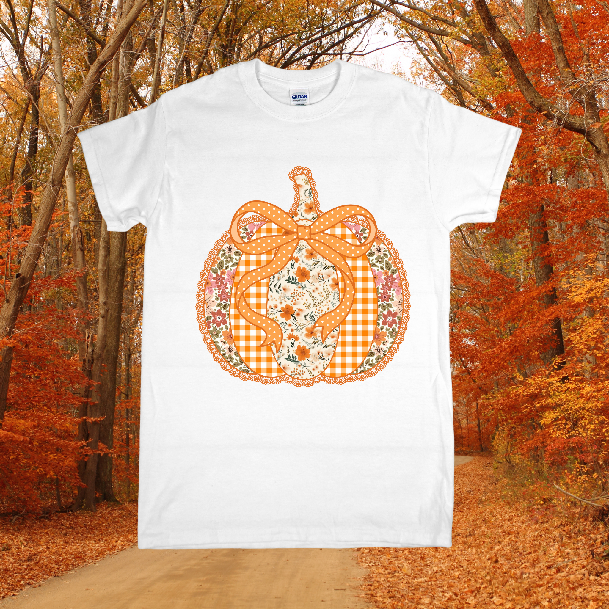 White t-shirt with a decorative pumpkin design in an autumn forest setting
