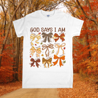 White t-shirt with colorful bows and 'God Says I Am' text in an autumn forest setting