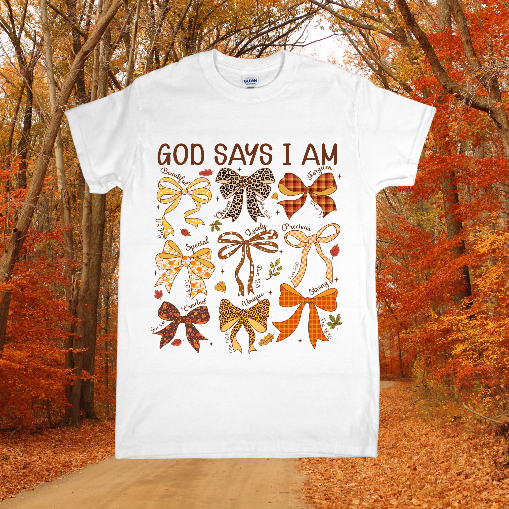 White t-shirt with colorful bows and 'God Says I Am' text in an autumn forest setting