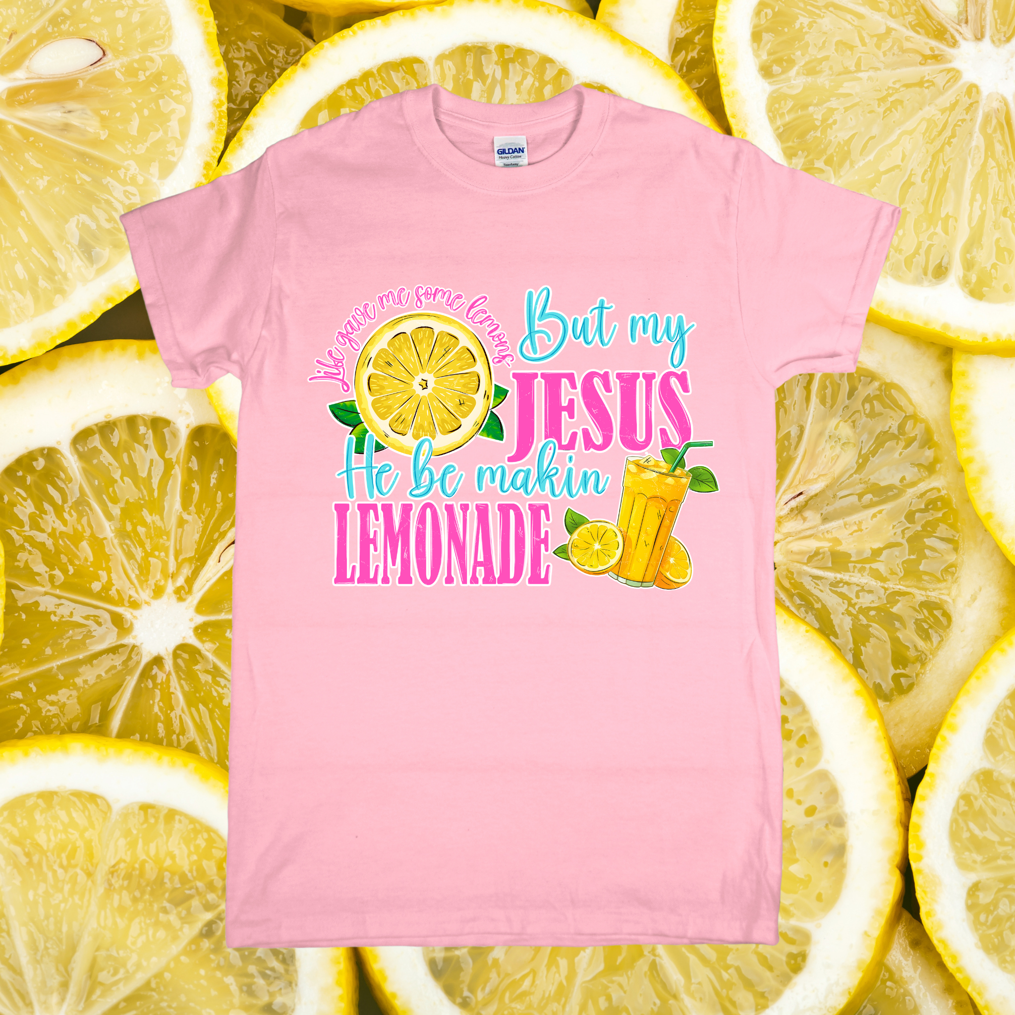 Pink t-shirt with colorful text and graphics on a background of lemon slices