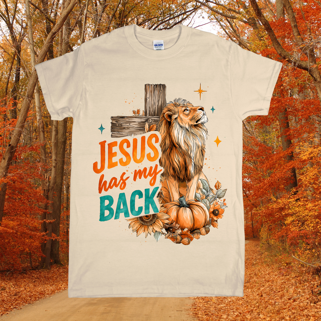 T-shirt with a lion and pumpkin design and 'Jesus has my back' text, set against an autumn forest background.