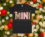 Black t-shirt with Christmas-themed design on a blurred festive background